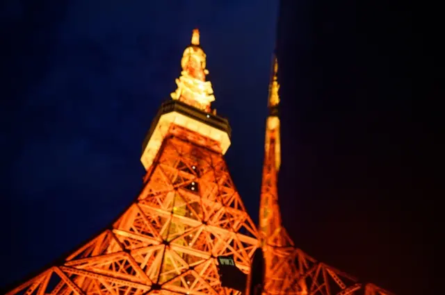 Tokyo Tower is lit up as people gather in their cars to watch move at a drive-in theatre event underneath the city landmark, in Tokyo on June 20, 2020,