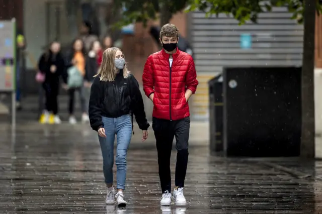 couple with masks walk