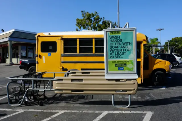 School bus behind CDC sign urging handwashing