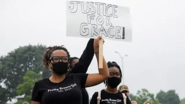 People hold signs during a protest