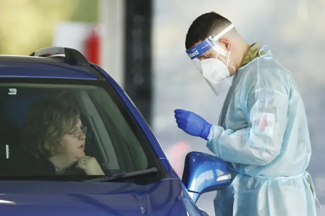 An Australian Defence Force member conducts a swab test a drive-through COVID-19 testing facility in Melbourne