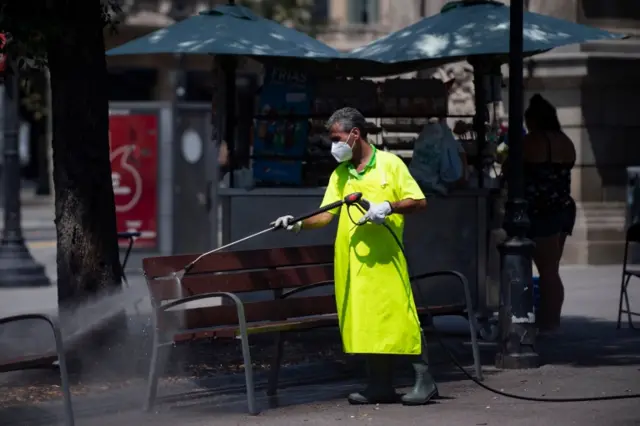 A worker cleans a bench in Barcelona