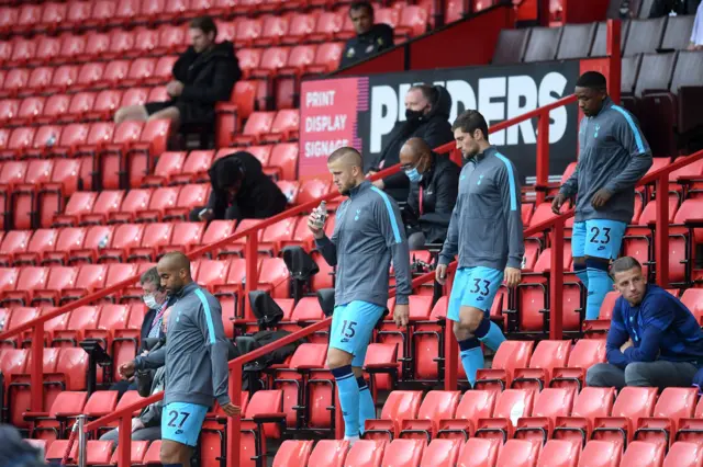 Tottenham Hotspur players walk through the stands on their way to the pitch