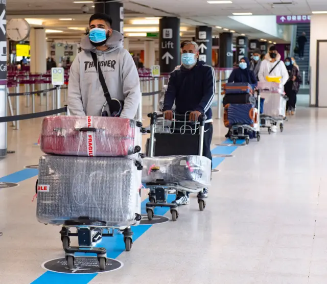 Travellers at Edinburgh Airport wearing masks