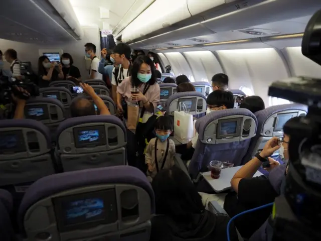 People board a China Airlines passenger jet during a fake travel experience