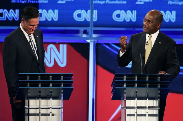 Herman Cain (right) and Senator Mitt Romney at a 2011 Republican debate