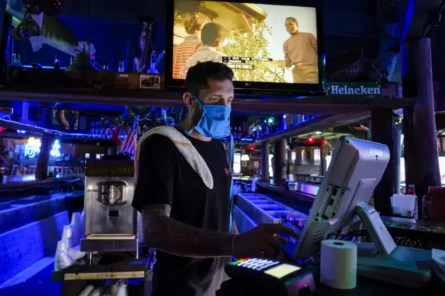 An employee works at an empty bar on Pensacola Beach, Florida