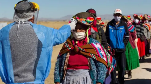 Health worker taking temperatures in Peru