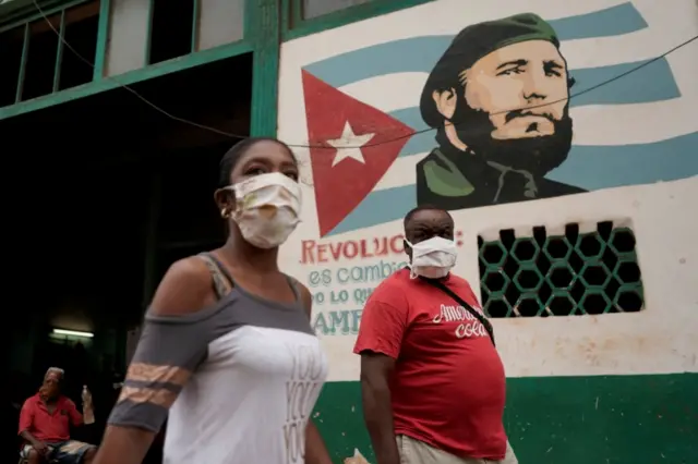 People pass by an image of late Cuban President Fidel Castro amid concerns about the spread of the coronavirus disease (COVID-19), in Havana, Cuba, 19 July 2020