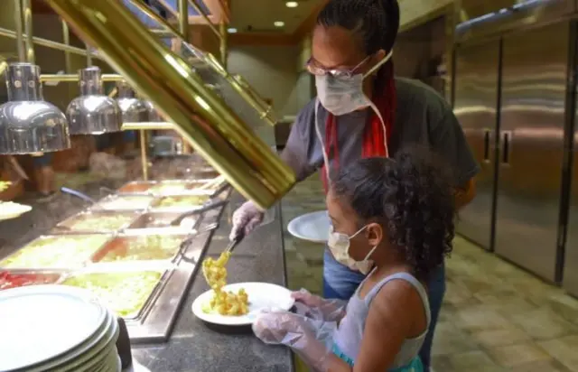 Family wearing masks at self-serve buffet