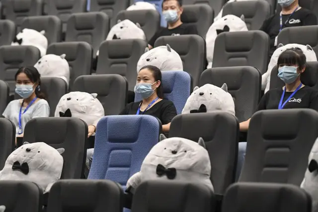 The official China News Service shows how one cinema has helped maintain this by separating people with cuddly toys.