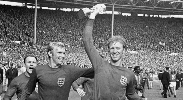 Jack Charlton holds World Cup trophy next to Bobby Moore