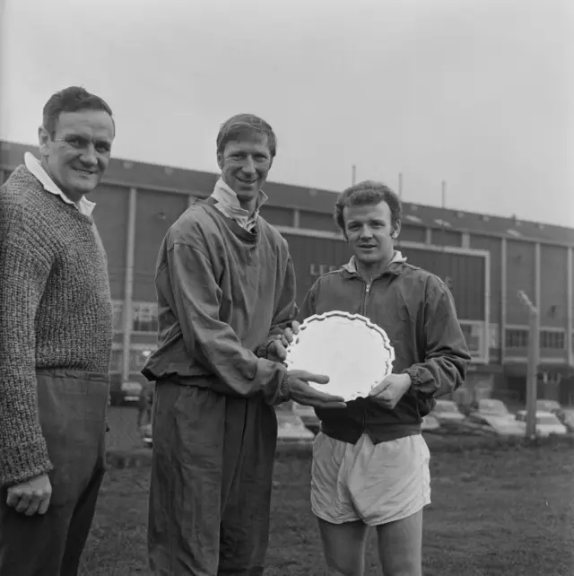 Charlton and Bremner hold award next to Revie