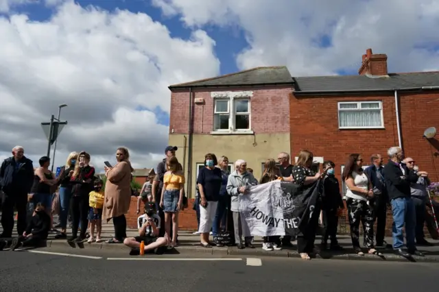 Crowd with flag on road side