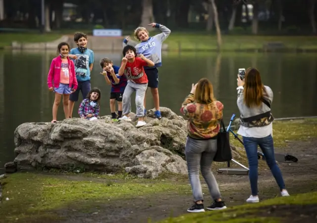 A group of children pose for a photo by the lake of Palermo in Buenos Aires,