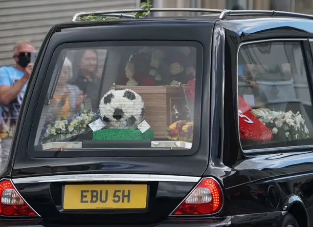 Floral football tribute in back of hearse