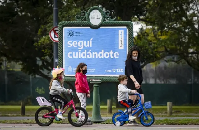 A woman walks with children through Palermo in Buenos Aires