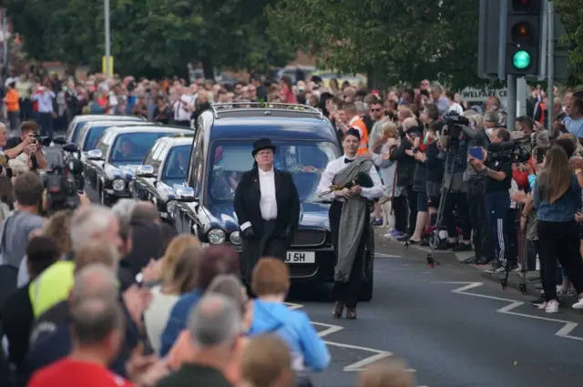 Crowds around hearse