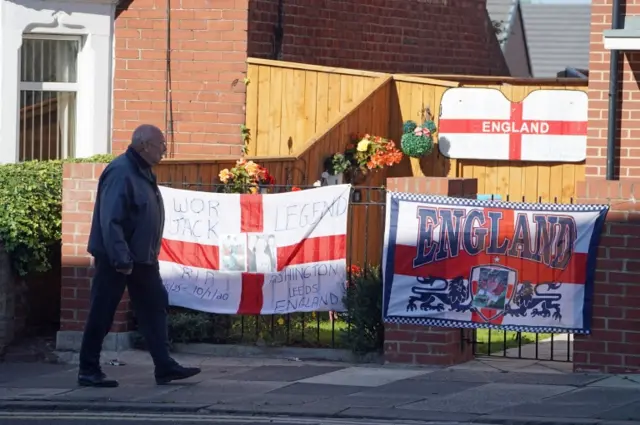 Man walks past England flags