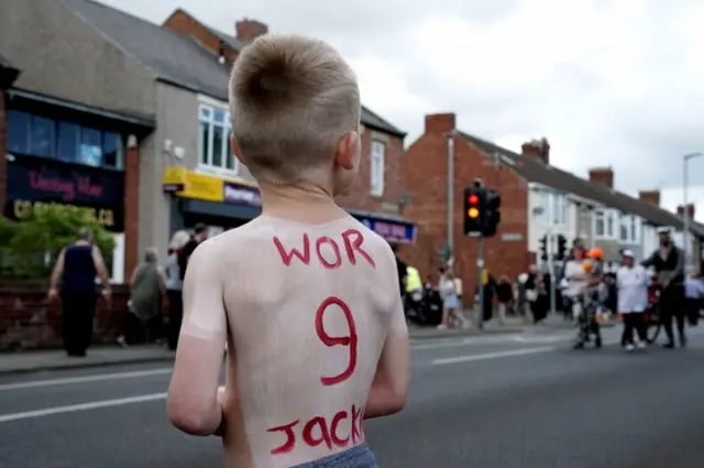 Lad with tribute painted on his back