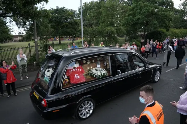 Crowds applaud hearse