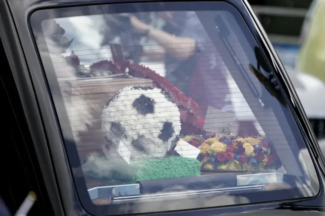 Floral tribute in back of hearse