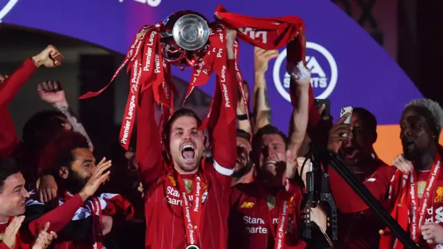 Liverpool captain Jordan Henderson lifts the Premier League trophy