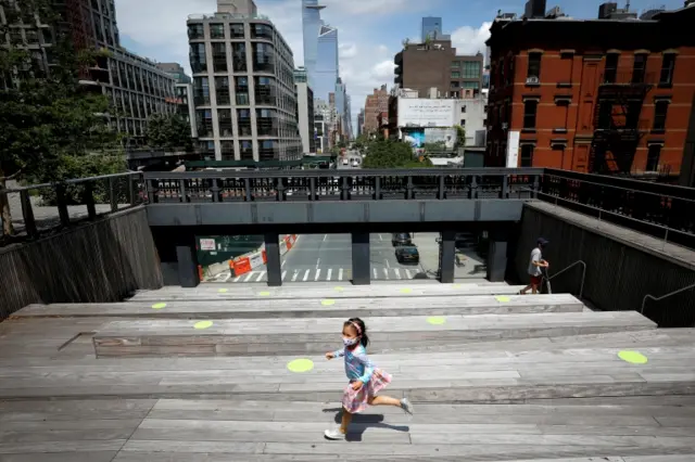 A girl wearing a mask runs in New York