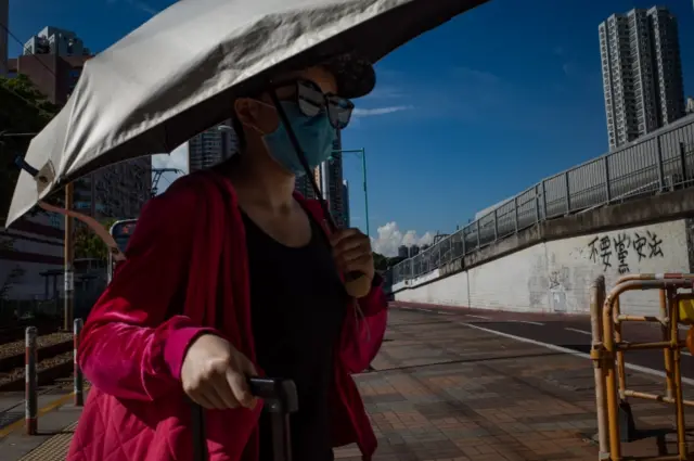 A woman wears a face mask while walking outside in Hong Kong