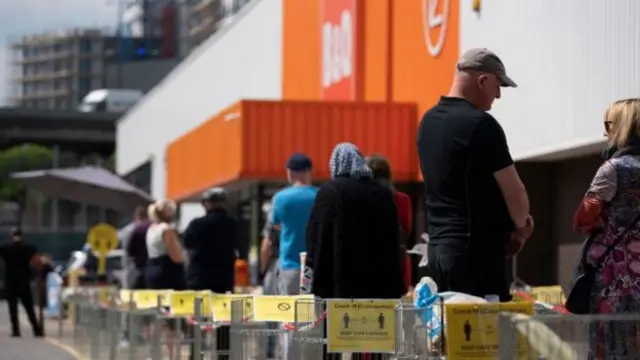 A long queue of people outside DIY shop B&Q