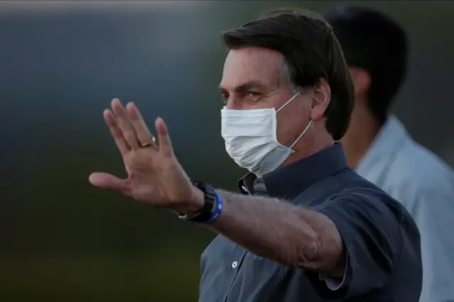 Jair Bolsonaro gestures during a ceremony to lower the Brazilian National flag down for the night, at the Alvorada Palace, amid the coronavirus disease (COVID-19) outbreak, in Brasilia, Brazil, July 20, 2020.