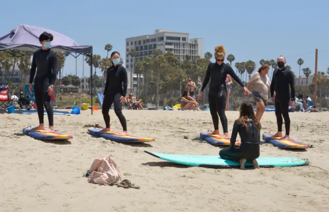 Surfers in Los Angeles don masks