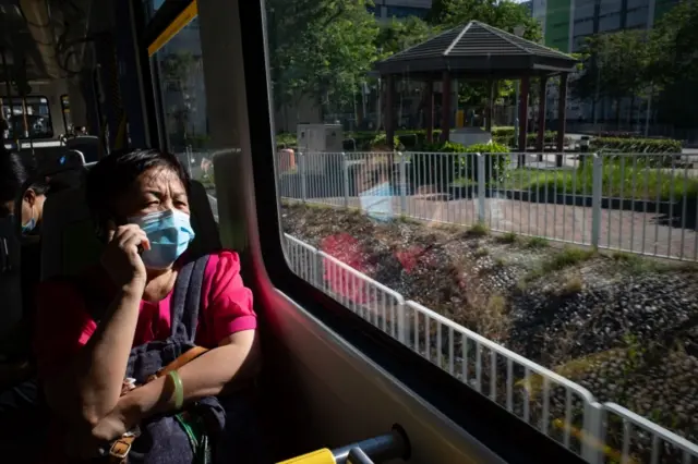 A woman wears a mask on a train