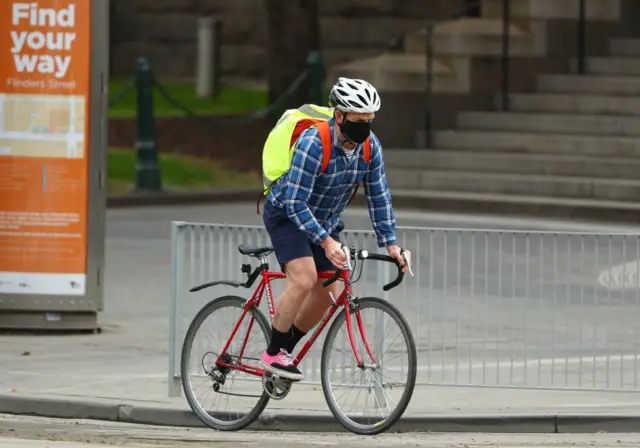 A cyclist wears a mask in Melbourne, Australia