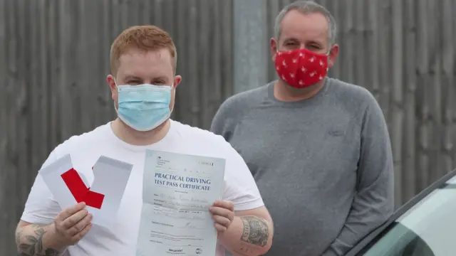 Kyle Duddridge with his driving instructor Dave Gilroy, after successfully completing his driving test in Liverpool. Driving tests, which were suspended across the UK in March, have restarted in England with a huge backlog after hundreds of thousands of tests were delayed or cancelled due to the coronavirus lockdown.