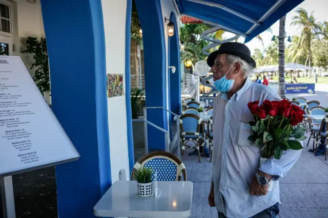 A man scans a restaurant menu in Miami