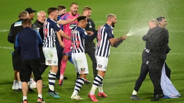 Charlie Austin of West Bromwich Albion sprays champagne after the result