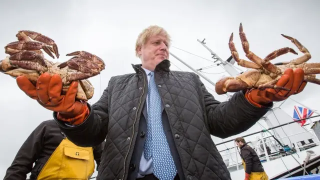 Boris Johnson holds some giant crabs in Orkney