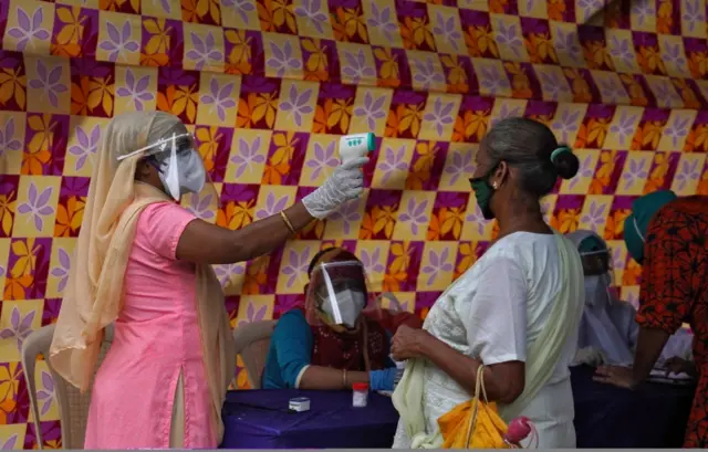 A woman has her temperature checked