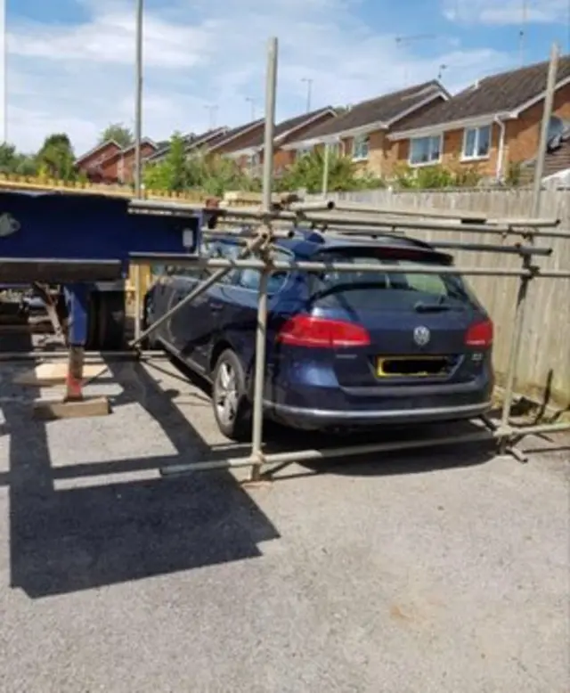 Car encased in scaffolding