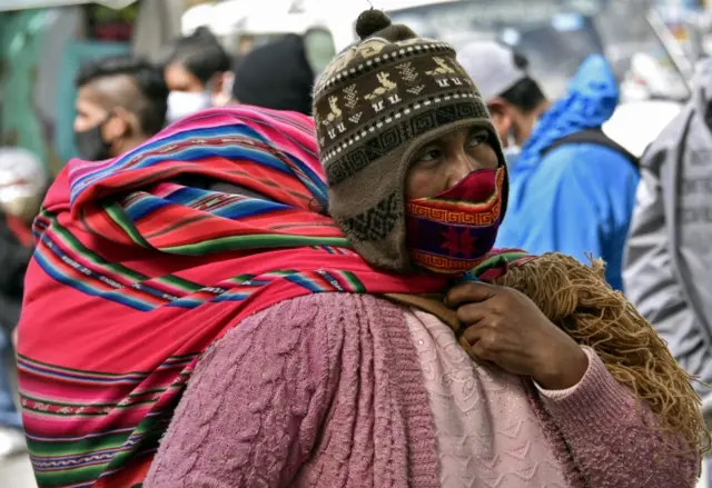 An Aymara indigenous woman wears a face mask as she walks along a street in la Paz, Bolivia, on 23 July 2020