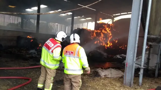 Firefighters next to fire