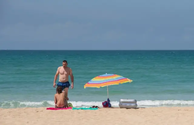 Tourists swim at a beach in Palma de Majorca