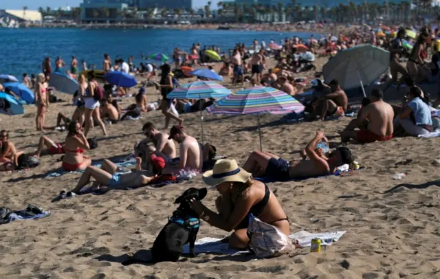 People enjoy the sunny weather at Barceloneta beach