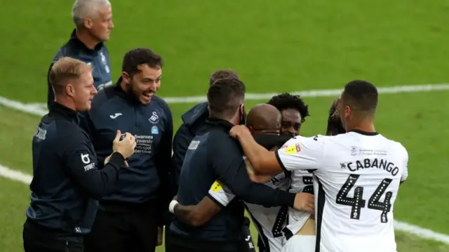 Andre Ayew celebrates with Swansea teammates and staff