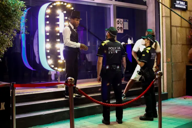 Police speak to a worker at a night club in Barcelona. Clubs were ordered to close by the Catalan government