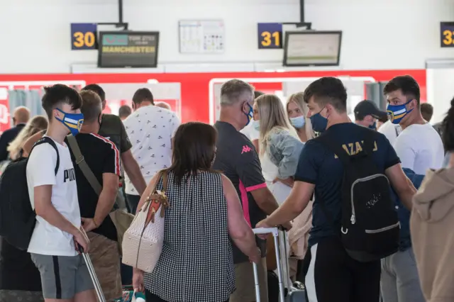 Travellers heading to Manchester, UK, queue up at the check-in in San Bartolome airport in Lanzarote, Canary Islands