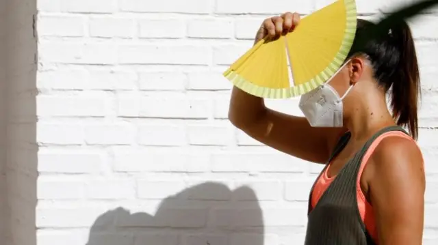 A woman shields her face from the sun in Cordoba, southern Spain, 20 July 2020