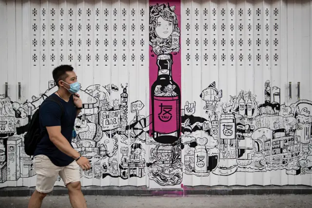 Man walks past mural in Hong Kong