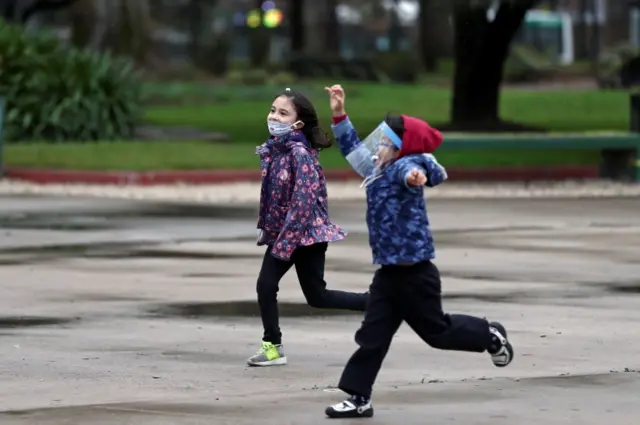 Children wearing protective face coverings play at a park as the government begins to ease quarantine restrictions imposed to slow the spread of the coronavirus disease (COVID-19), in Buenos Aires, Argentina July 23, 202